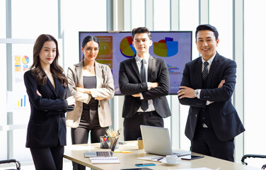 Asian young professional successful male and female businessmen and businesswomen in formal business suit standing side by side smiling holding hands bonding united together in company meeting room