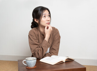 Asian woman is concentrating on reading a book at home in her leisure time 