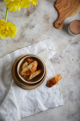Set of ceramic plates on light rust textured background. Copy space. Homemade bagels, croissants.