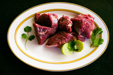 Fresh Beef Steaks decorated with vegetables and herbs on a white plate,Selective focus.