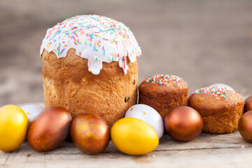 Colored Easter eggs and willow on  wooden background .