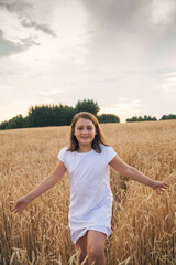 Child in   white dress on   walk in   field in summer