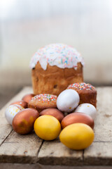 Colored Easter eggs and willow on  wooden background .