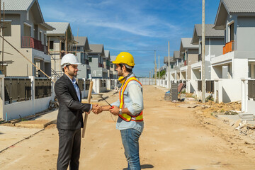 Project Manager consults with Foreman, man holding walkie talkie jogging tokki to check the...