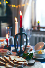Festive still life of tea, cake, tangerines and candles. Christmas Eve and New Year's Eve. Vertical photo.