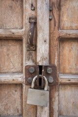 Ancient wooden door with iron padlock. Traditional door in Stone town, Zanzibar. Home security concept. Grunge old doorway with rusty lock. Weathered door with knocker. Closed home entrance.