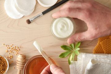 Moisturizing skin care cream with honey extracts on yellow table