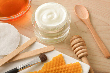 Moisturizing skin care cream with honey extracts on table detail