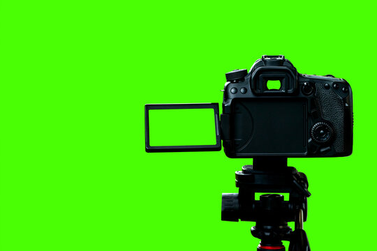 The DSLR. camera with empty screen on the tripod, isolated on green background. The chroma key, Green screen with clipping path
