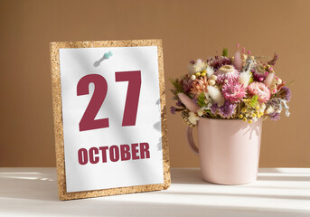 october 27. 27th day of month, calendar date.Bouquet of dead wood in pink mug on desktop.Cork board with calendar sheet on white-beige background. Concept of day of year, time planner, autumn month
