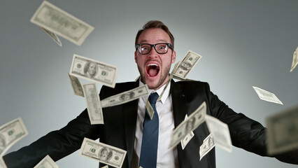 Close-up of screaming businessman with flying dollars banknotes