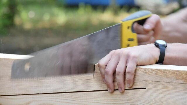 Man scooping a plank of wood/Homme scillant une planche de bois