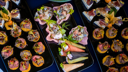 Decorated catering banquet table with different food appetizers assortment on a party