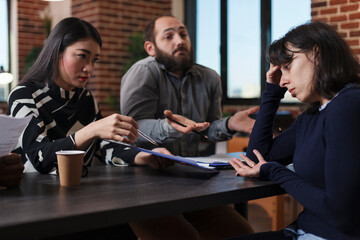 Tired recruiter listening to irritated job applicants complaining about absurd salary offer while...