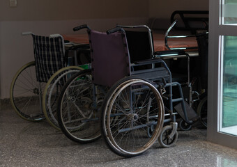 Fototapeta na wymiar Hospital wheelchairs. Wheelchairs parked on the side of a hospital hallway.