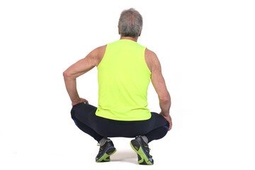 back view of a senior man with sportswear squatting on white background