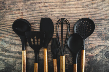 set of matching wooden and silicone kitchen utensils, cooking meals at home or learning to cook