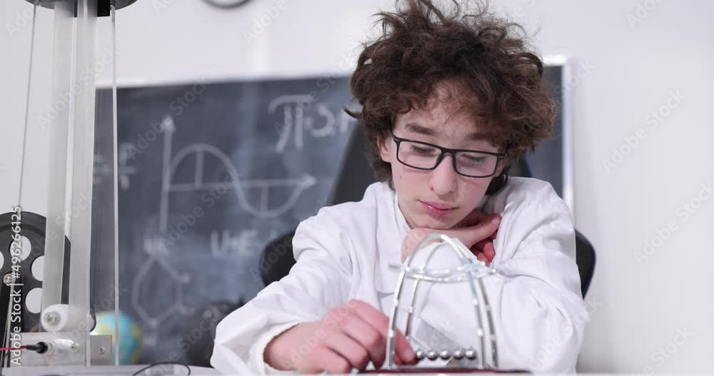 Wall mural schoolboy experimenting in physics class. young student doing physics experiment in the classroom