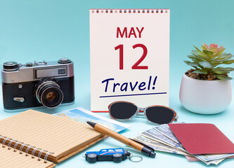 Travel planning, vacation trip - Calendar with the date 12 May glasses notepad pen camera cash passports.