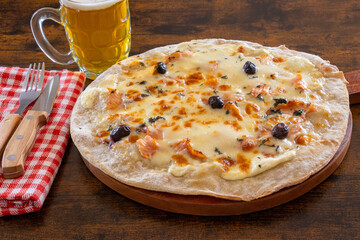 pizza with smoked salmon and cream on a wooden table