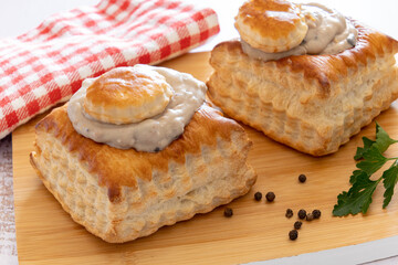 puff pastry garnished with veal rice on wooden board