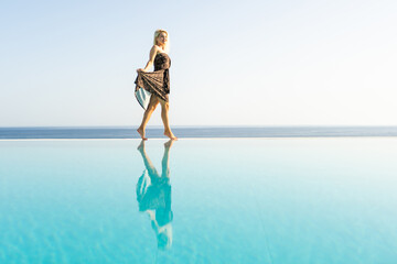 Summer in the city. Happy young woman near swimming pool.