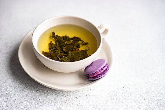 Cup of green Soursop tea with a lavender macaroon