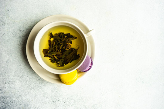 Cup of green Soursop tea with lemon and lavender macaroons