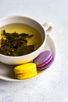 Cup of green Soursop tea with lemon and lavender macaroons