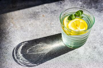 Glass of lemon water with mint on a  table