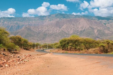 A vehicle on a highway against the background of Kerio Escarpment in Baringo County, Kenya