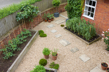 Landscaped garden design with gravel and raised beds, UK