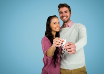 Portrait of caucasian couple holding their house keys together against copy space on blue background