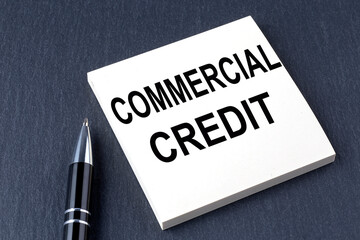 COMMERCIAL CREDIT text on the sticker with pen on the black background