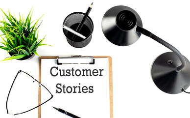 CUSTOMER STORIES text on a clipboard on the white background