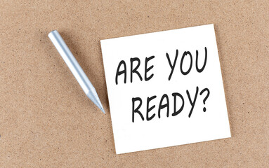 ARE YOU READY text on sticky note on a cork board with pencil ,
