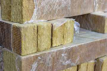 Rock mineral wool at a construction site. Close-up. Mineral wool folded on a pallet in cellophane packaging.