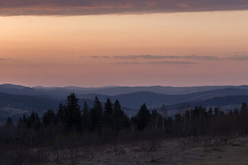 An evening with a blazing sky in the Carpathian Mountains. Landscape of the Carpathian mountains with a blazing evening sky on the horizon.
