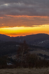 An evening with a blazing sky in the Carpathian Mountains. Landscape of the Carpathian mountains with a blazing evening sky on the horizon.