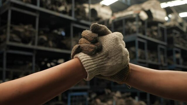 Close up of factory engineer team worker join unity hand in hand together. Slow motion.