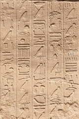 Ancient Egyptian murals and hieroglyphs on the stone walls of the Karnak Temple in Luxor, Egypt