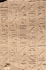 Ancient Egyptian murals and hieroglyphs on the stone walls of the Karnak Temple in Luxor, Egypt