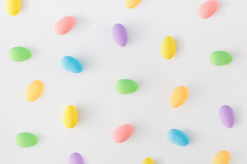Artificial styrofoam eggs of various colors on white background.