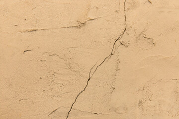 Crack on old dirty yellow paint concrete wall of cement surface broken background damage texture