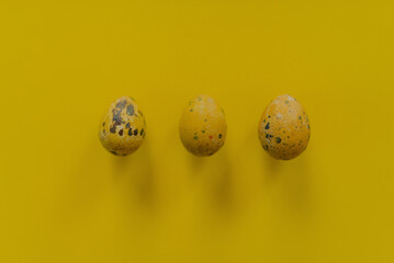 Easter holiday background. Pastel coloured decorated easter eggs on a bright yellow background