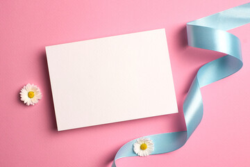 Invitation card mockup with blue ribbon and white daisy flowers on pink