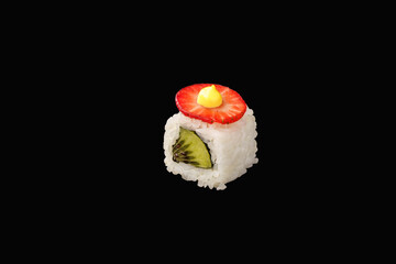 hosomaki roll with kiwi, strawberries, Japanese mayonnaise, unagi sauce, rice. isolated on black background