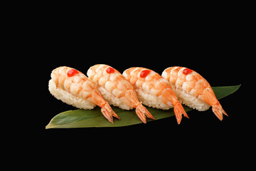 Nigiri sushi tiger shrimp, sriracha sauce, chives, banana leaf. japanese food on isolated black background, japanese menu.