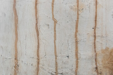 Old dirty concrete white wall with streaks of rusty water weathered background cement obsolete texture