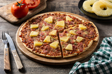 Hawaiian pizza with pineapple,ham and cheese on wooden table	